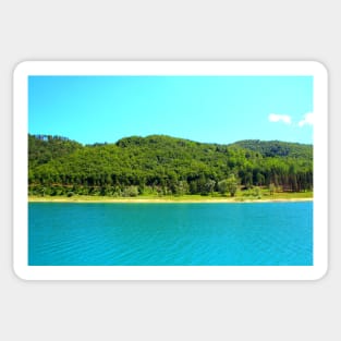 Scenery at Gerosa Lake with light blue waters rippling in front of the green shore Sticker